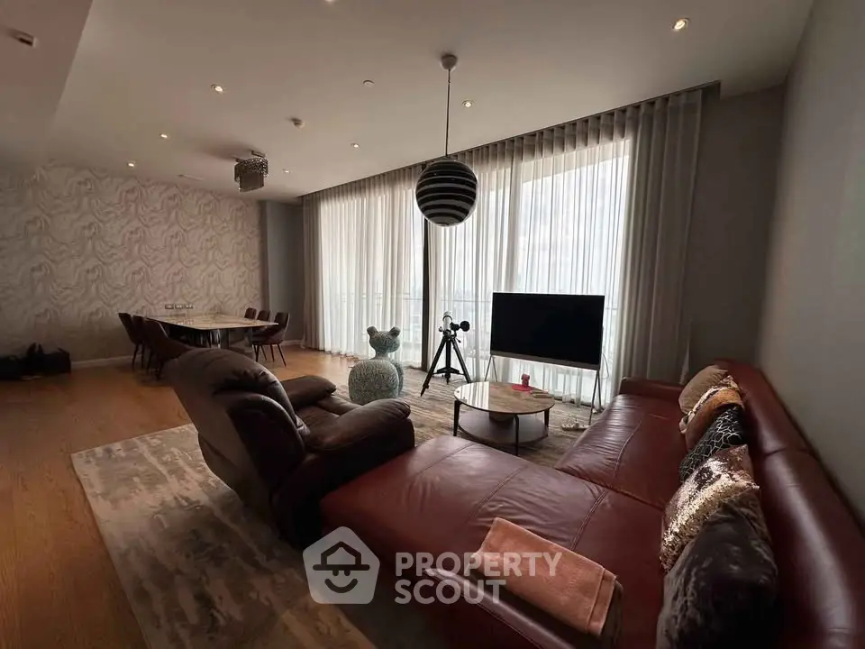 Luxurious living room with modern decor and large windows in upscale apartment.