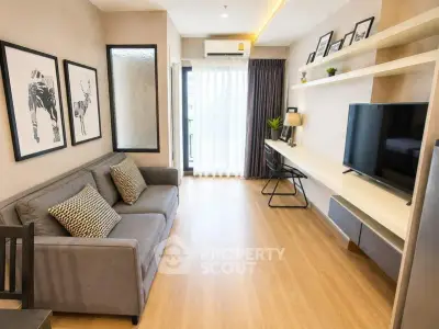 Modern living room with stylish decor, large TV, and natural light from balcony.