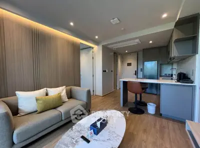 Modern living room with cozy sofa and stylish kitchen area in open layout apartment.