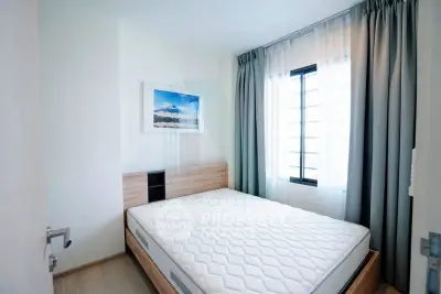 Bright and cozy bedroom with modern decor and large window for natural light.