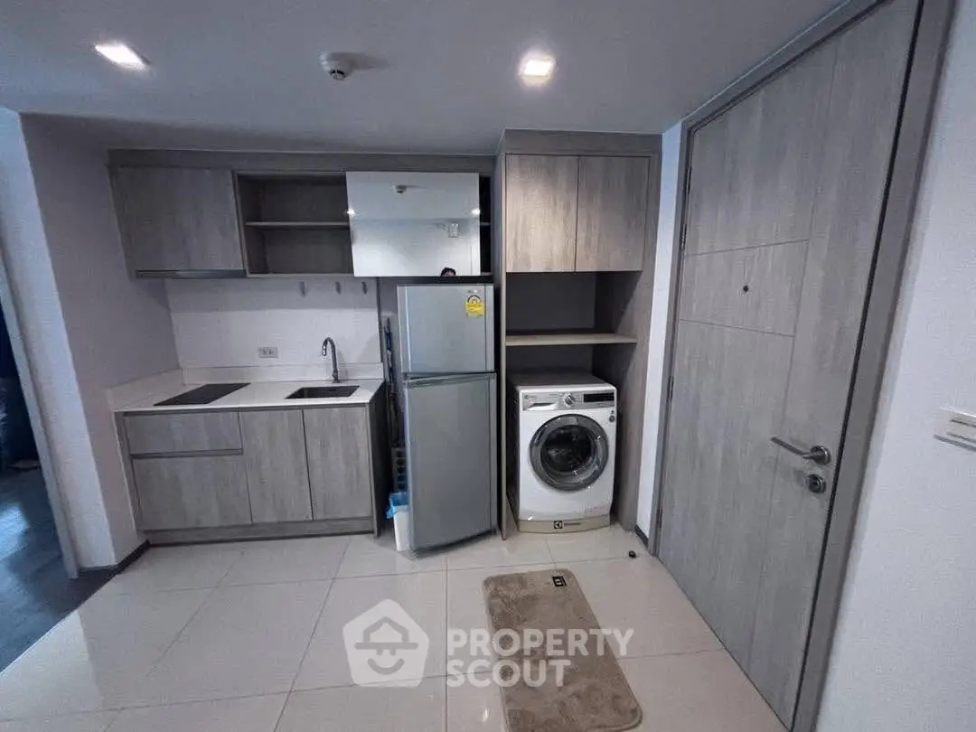Modern kitchen with washing machine and fridge in compact layout
