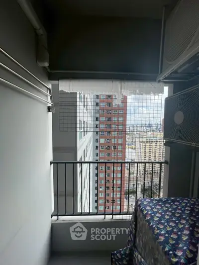 High-rise balcony with city view and air conditioning unit