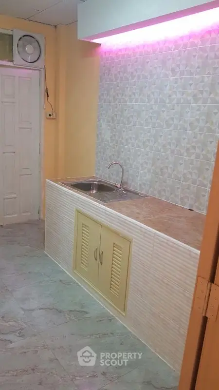 Compact kitchen with tiled backsplash and under-cabinet lighting