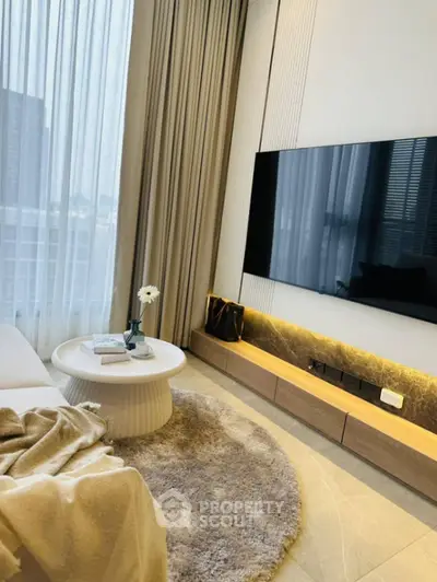 Modern living room with stylish decor and large wall-mounted TV