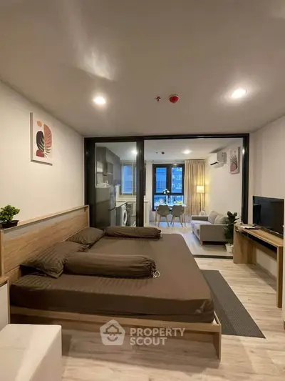 Modern studio apartment with open layout, featuring a cozy living area, stylish decor, and a compact kitchen.