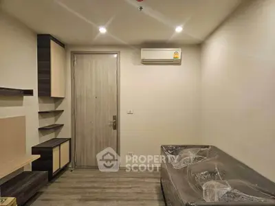 Modern minimalist living room with sleek furniture and air conditioning unit.