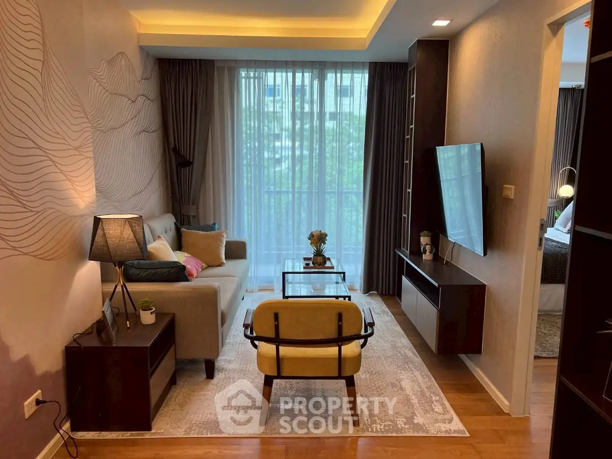 Stylish modern living room with floor-to-ceiling windows and elegant decor in a cozy apartment.