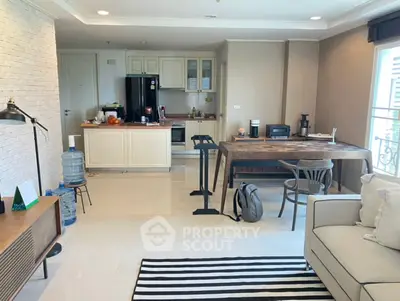 Spacious open-plan living room with modern kitchen and dining area, featuring stylish decor and ample natural light.