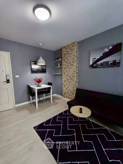Modern living room with stylish decor and dining area, featuring elegant lighting and contemporary artwork.