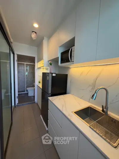 Modern compact kitchen with sleek cabinetry and integrated appliances