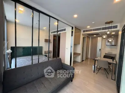 Modern apartment interior with glass partition, stylish living area, and dining space.