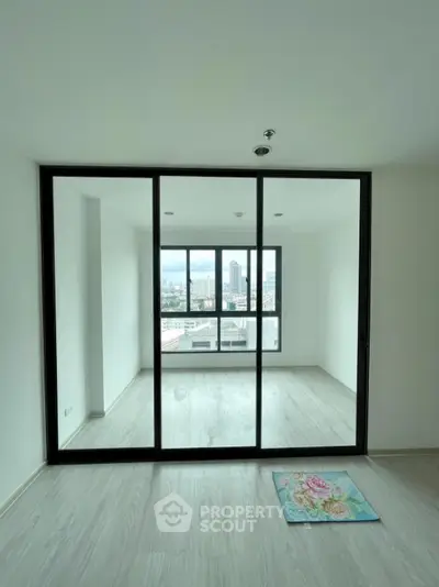 Spacious modern room with large windows offering city views and sleek flooring