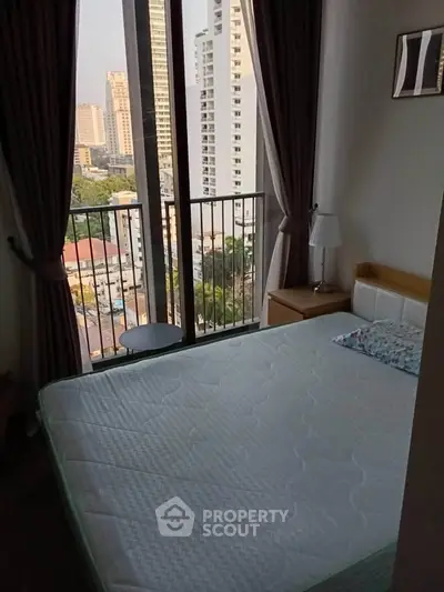 Cozy bedroom with city view and large windows in modern apartment