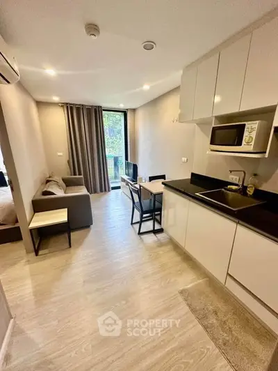 Modern open-layout kitchen and living area with sleek design and natural light.