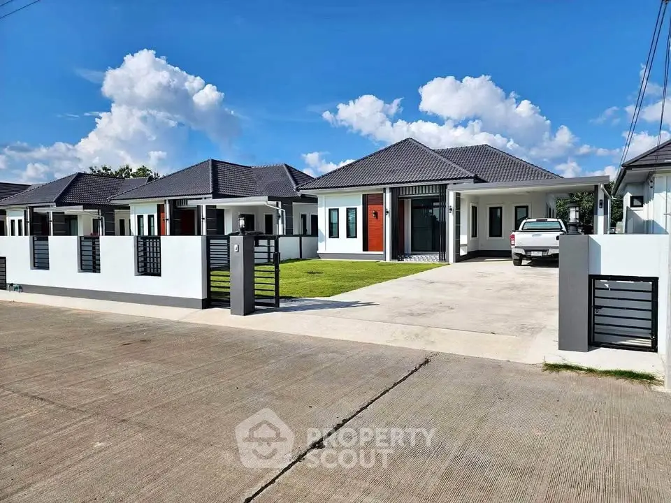 Modern single-story house with driveway and carport in a serene neighborhood.