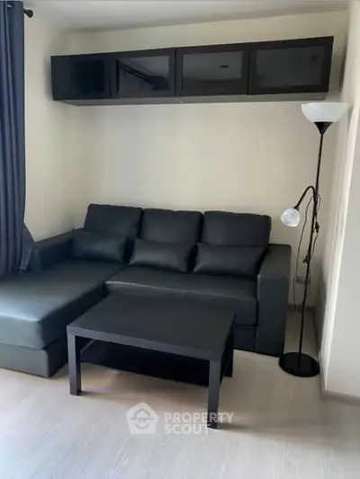 Modern living room with black sofa and sleek furniture design.