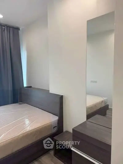 Modern bedroom with sleek furniture and natural light, perfect for a cozy living space.
