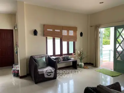 Charming living room with cozy seating and natural light, perfect for relaxation and entertaining.