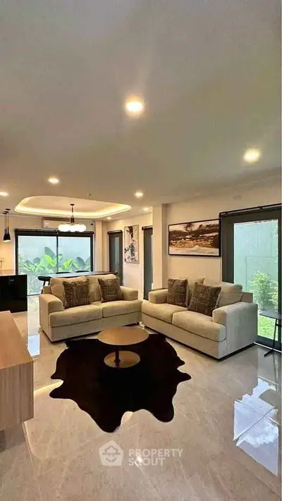 Spacious modern living room with elegant decor and large windows for natural light.