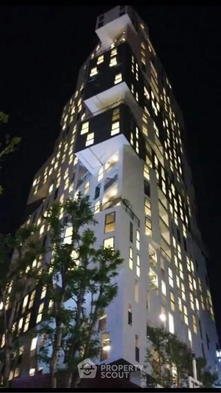 Stunning night view of a modern high-rise building with illuminated windows.