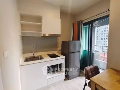 Modern compact kitchen with balcony view in urban apartment