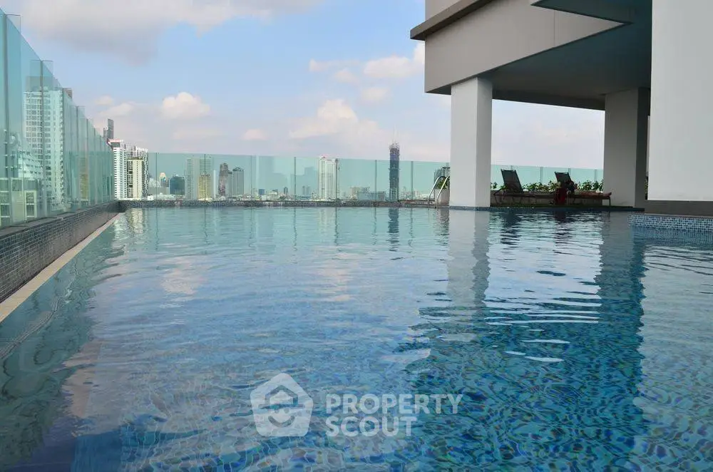 Stunning rooftop pool with city skyline views in modern high-rise building.