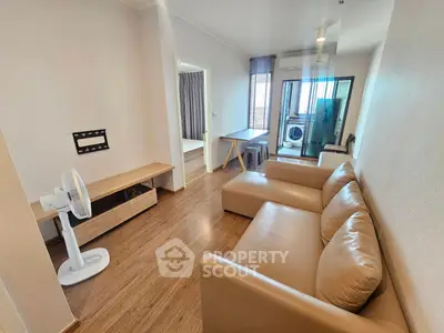 Modern living room with leather sofa and wooden flooring in a cozy apartment.