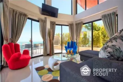 Stunning modern living room with panoramic ocean views and vibrant decor.