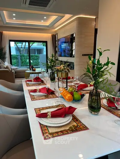 Luxurious dining area with elegant table setting and spacious living room view.