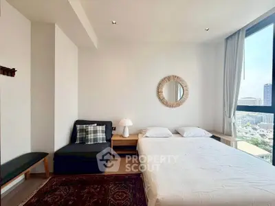Bright and airy bedroom with city view, featuring modern decor and cozy seating area.