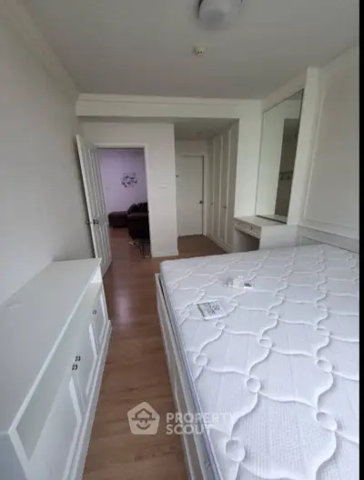 Spacious bedroom with modern design and ample storage in a stylish apartment.