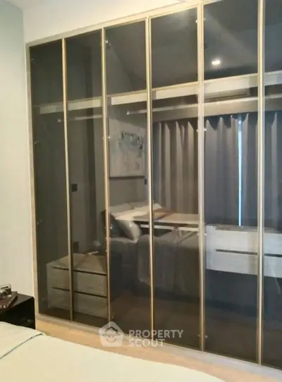 Modern bedroom with sleek glass wardrobe and cozy ambiance