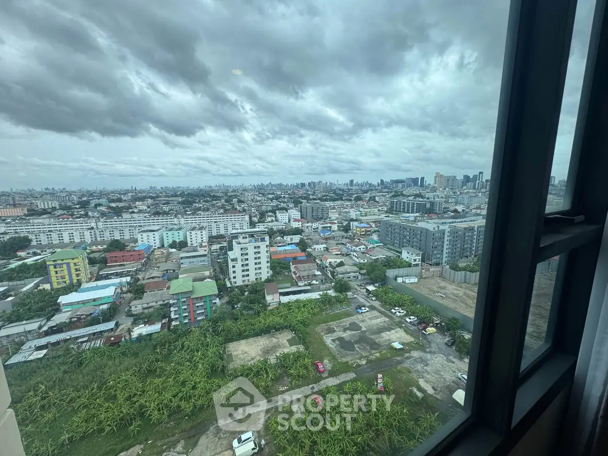 Stunning cityscape view from high-rise window showcasing urban skyline and residential buildings.