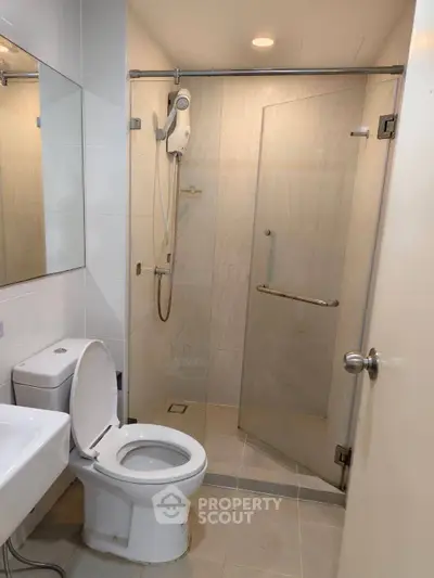 Modern bathroom with glass shower and sleek fixtures in a contemporary apartment.