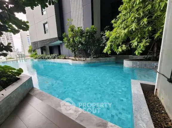 Luxurious poolside view with lush greenery at modern residential complex.