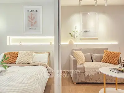 Chic modern bedroom with cozy seating area, stylish decor, and warm lighting.