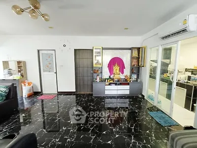 Spacious living room with marble flooring and modern decor, featuring a unique wall clock and sliding glass doors.