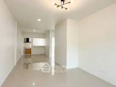 Spacious modern living room with sleek tile flooring and stylish lighting fixture.