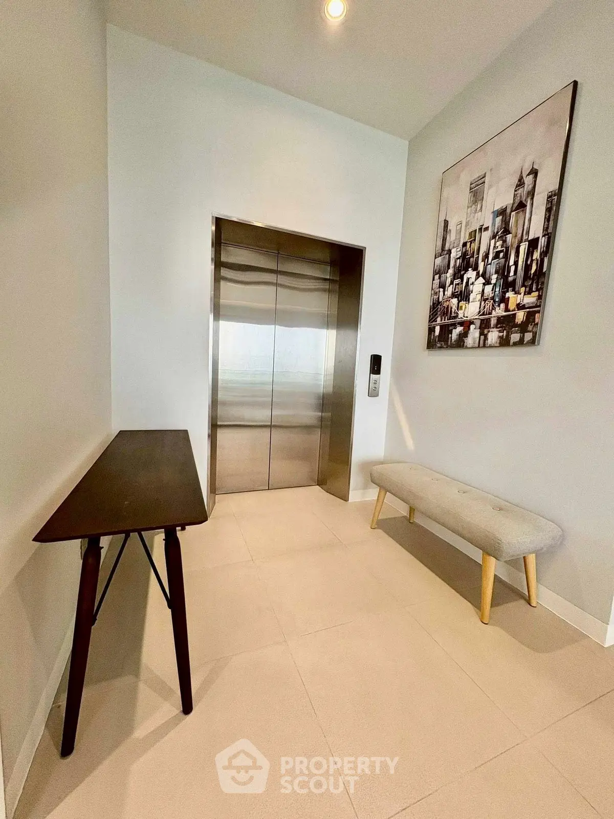 Modern elevator lobby with stylish decor and cityscape artwork.