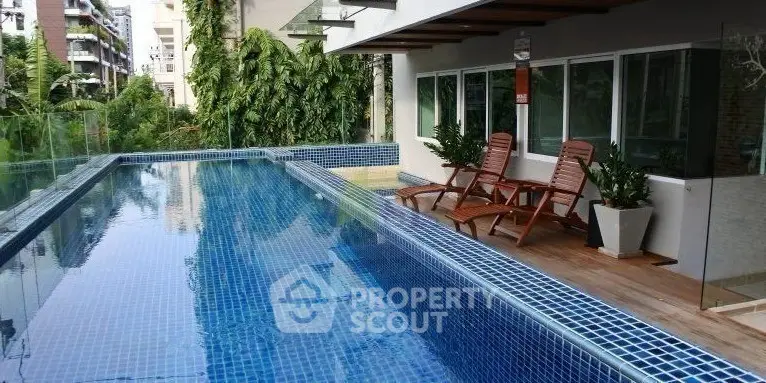Luxurious outdoor pool area with modern design and lush greenery, perfect for relaxation and leisure.