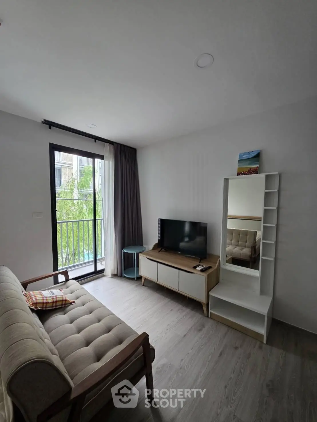 Modern living room with balcony view, featuring stylish furniture and natural light.