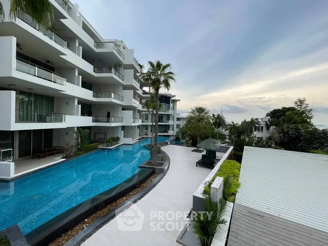 Luxurious modern apartment complex with stunning pool and lush greenery, perfect for upscale living.