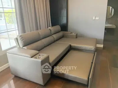 Modern living room with sleek gray sectional sofa and large window, perfect for relaxation and comfort.