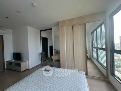 Modern bedroom with large windows and built-in wardrobe in a stylish apartment.