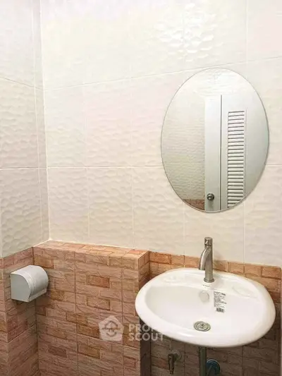 Modern bathroom with stylish sink and round mirror