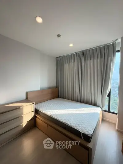 Modern bedroom with large window and city view, featuring sleek wooden furniture and neutral decor.