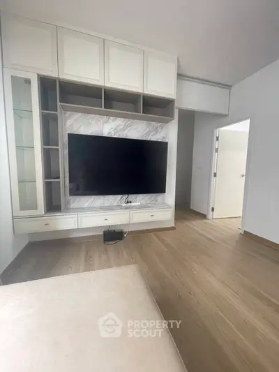 Modern living room with built-in TV unit and sleek wooden flooring