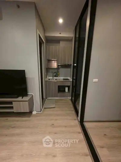 Modern compact kitchen with sleek cabinetry and integrated appliances in a stylish apartment.