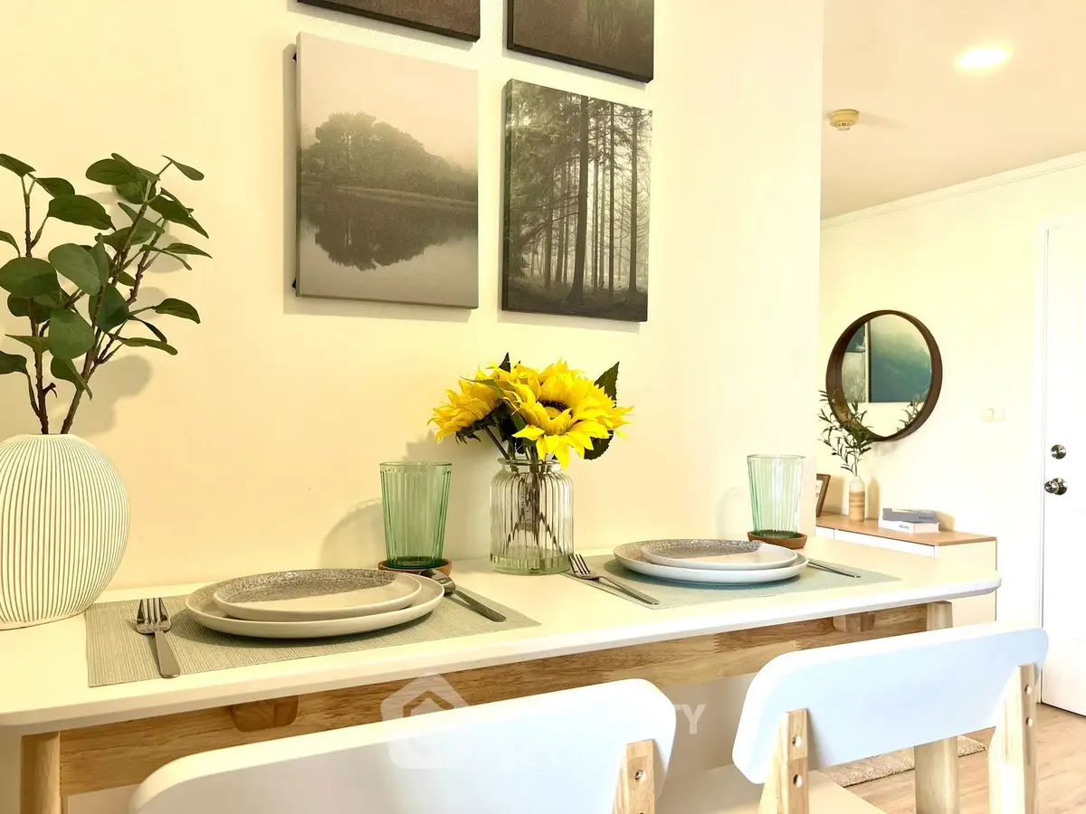 Charming dining area with elegant table setting and wall art in cozy home interior.