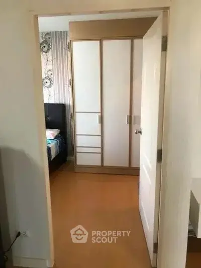 Cozy bedroom with wooden flooring and a spacious wardrobe, perfect for modern living.